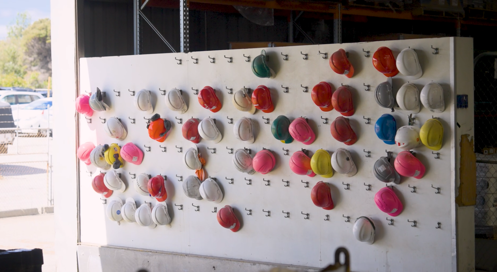Image of various PPE hard hats hung on a wall at Austal's Henderson shipyard.