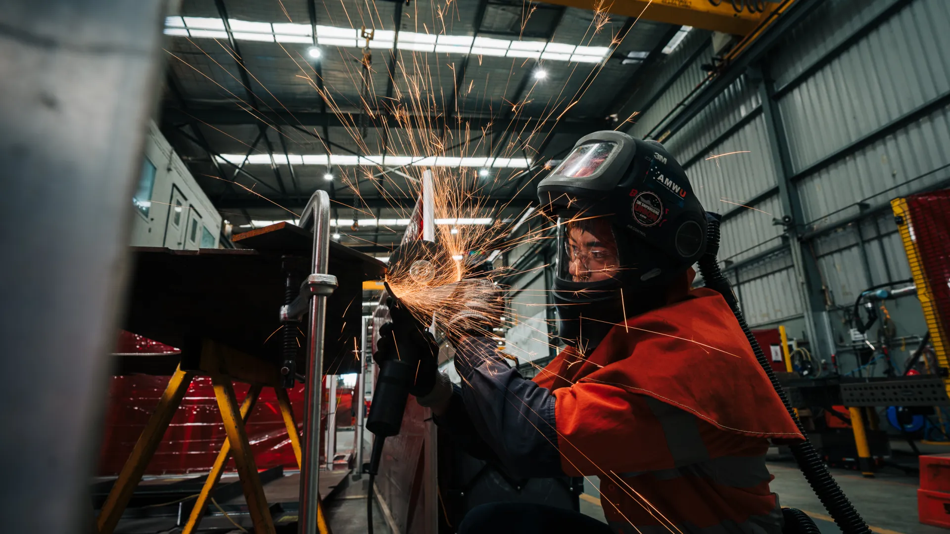 Image of Austal employee grinding steel.