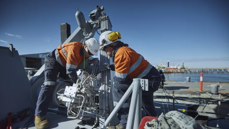 Image of two workers onboard a ship.