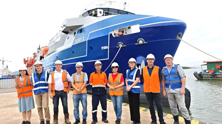 Representatives of Austal Vietnam and Degage Group standing in front of Dory 2 at the Vung Tau shipyard to mark the vessel's handover